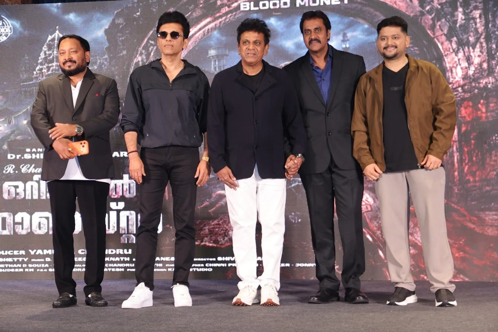 Shivarajkumar with the Original Monster team on stage at the Mumbai title launch