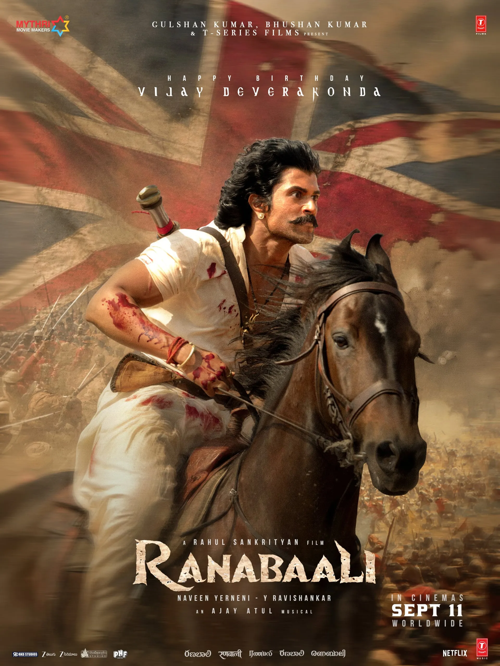 Ranabaali poster: Vijay Deverakonda on horseback in a bloodied white shirt, sword strapped behind, Union Jack burning in the background