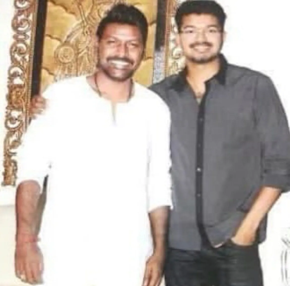 Older photo of Raghava Lawrence in a white kurta with a younger Vijay in a black shirt