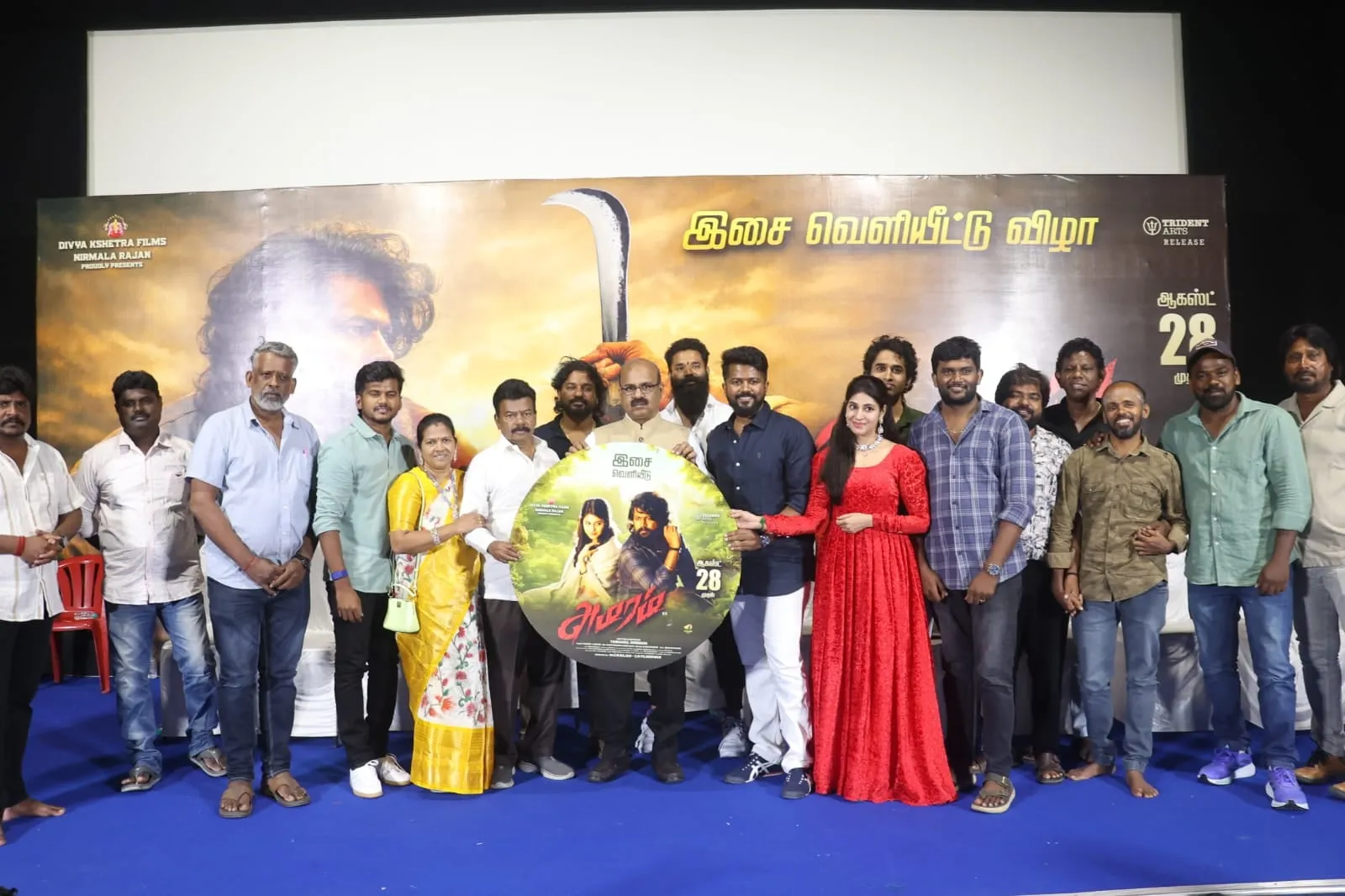 The Amaram team on stage holding the film's circular audio disc at the launch in Chennai