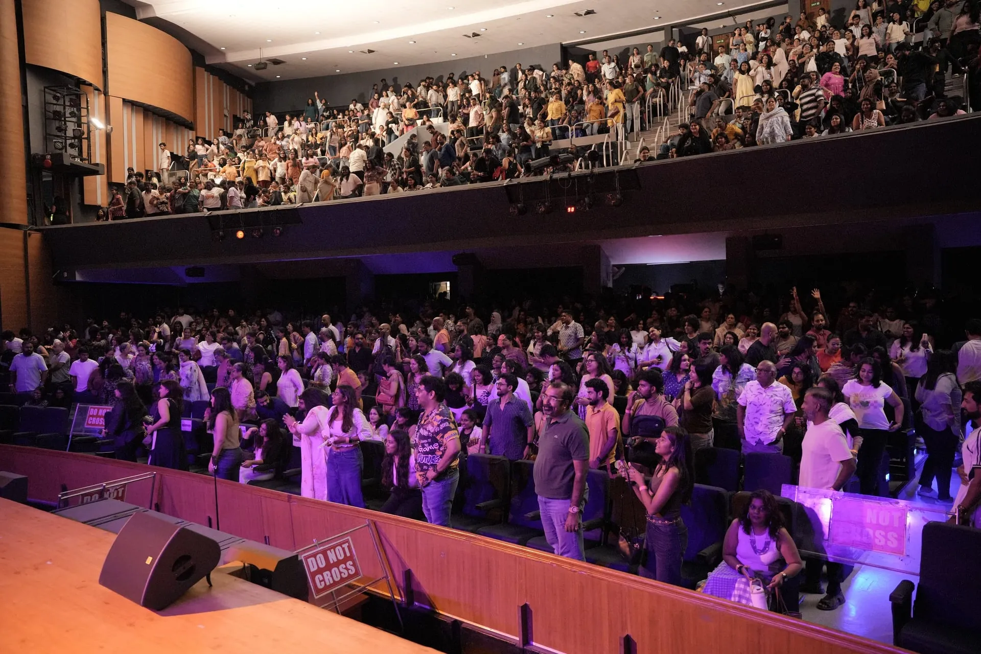A packed Music Academy auditorium across both tiers, with the audience on its feet during Maya S. Krishnan's Pomblel