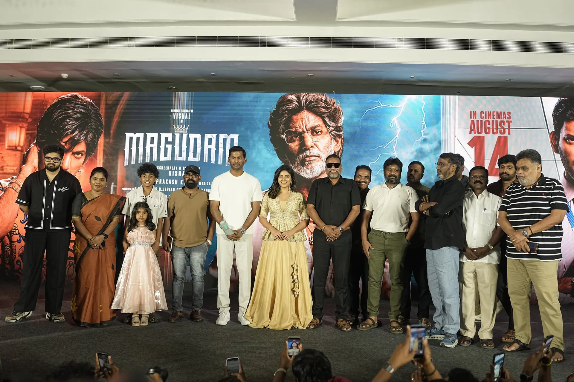 Vishal, Anjali and the Magudam team on stage at the trailer launch, with the film's August 14 release date on the backdrop
