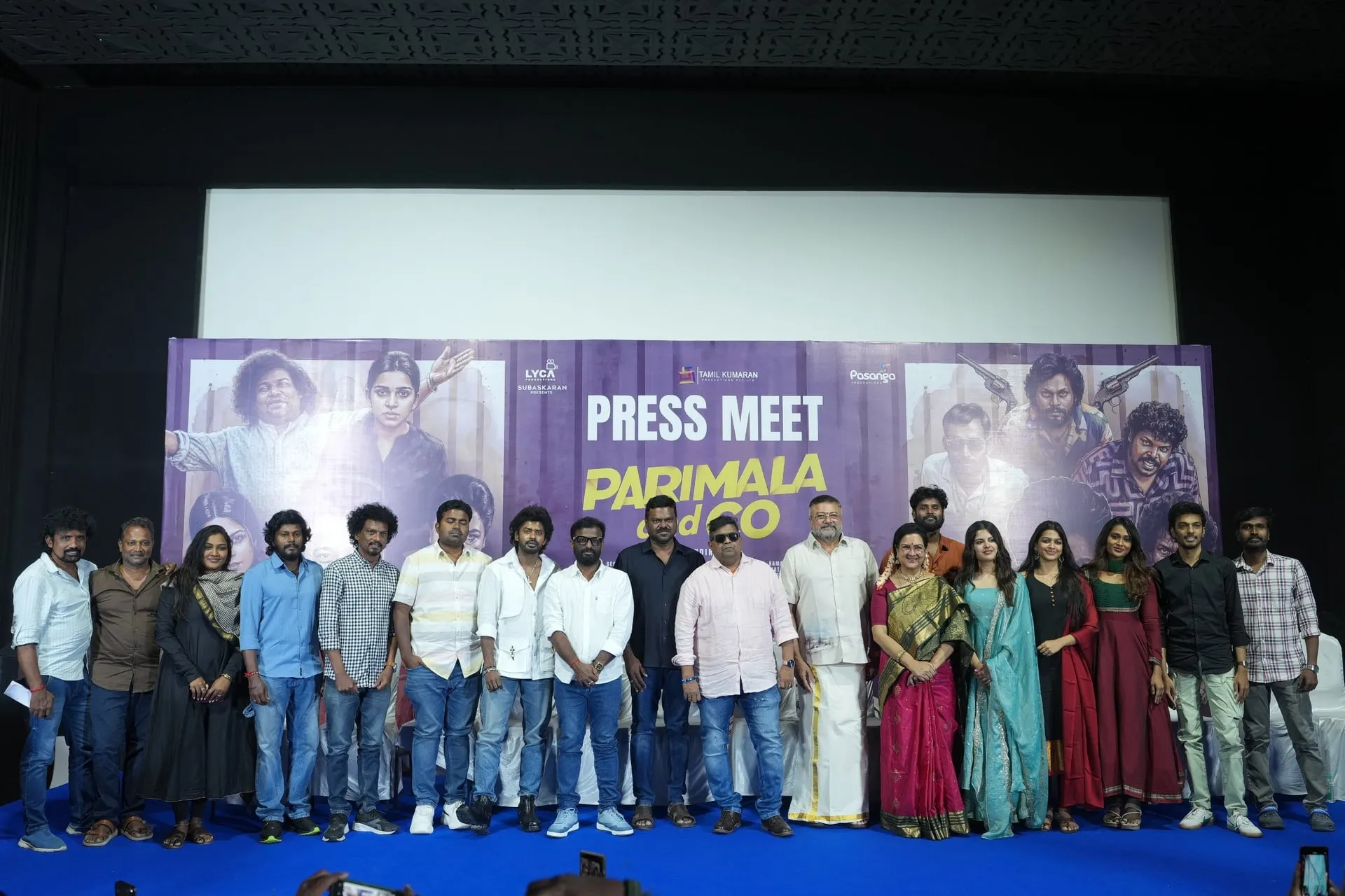 The cast and crew of Parimala & Co lined up on stage in front of the film's backdrop in Chennai