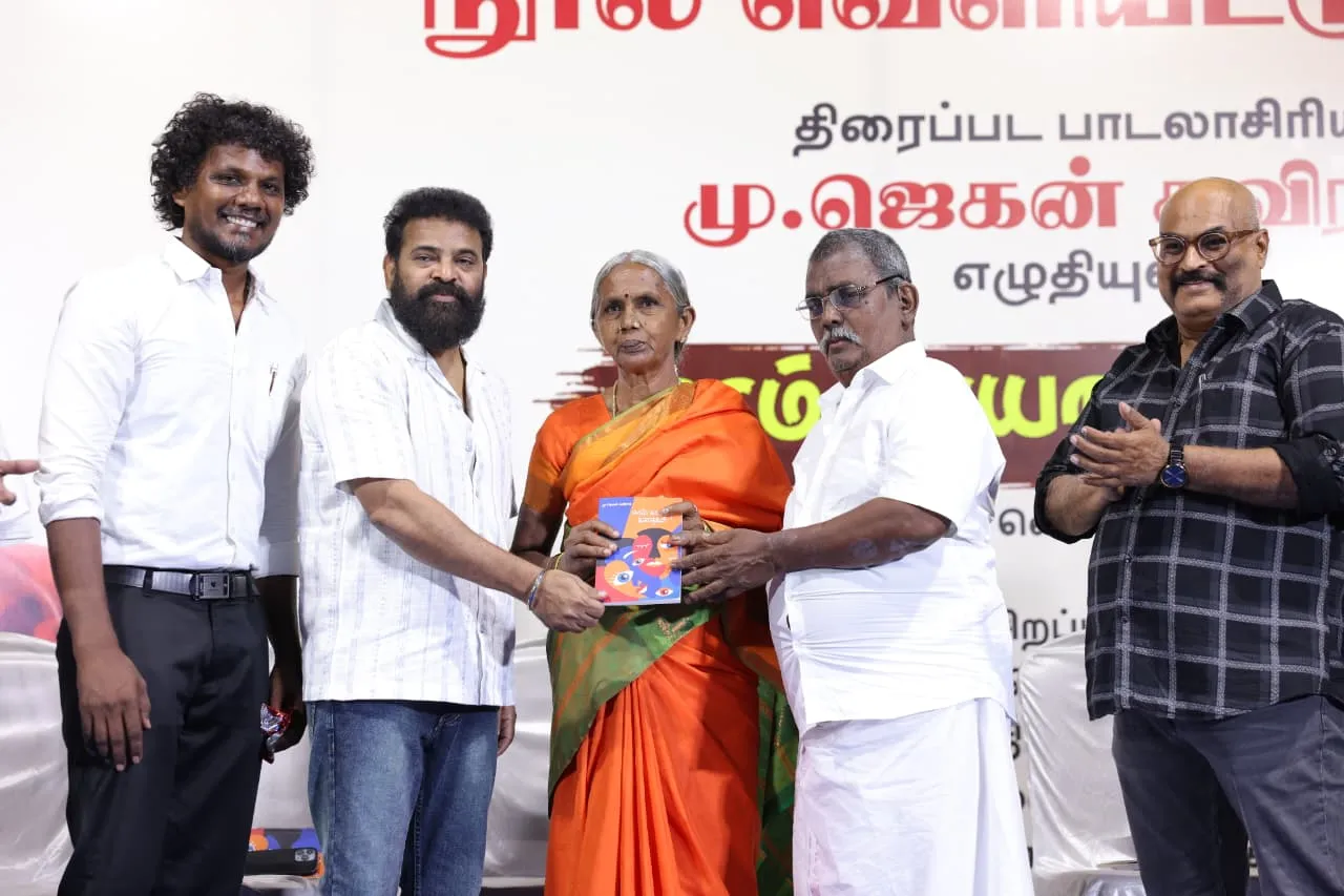 Director Ameer hands a copy of Eeram Kaayaatha Kathaigal to Jegan Kaviraj's parents on stage