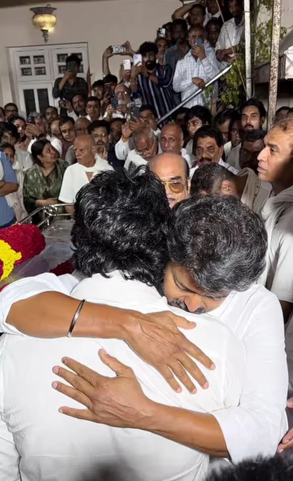 Vijay shares a long embrace with Jiiva at producer RB Choudhary's Chennai residence on Wednesday evening, both in white kurtas, surrounded by mourners and phone cameras.