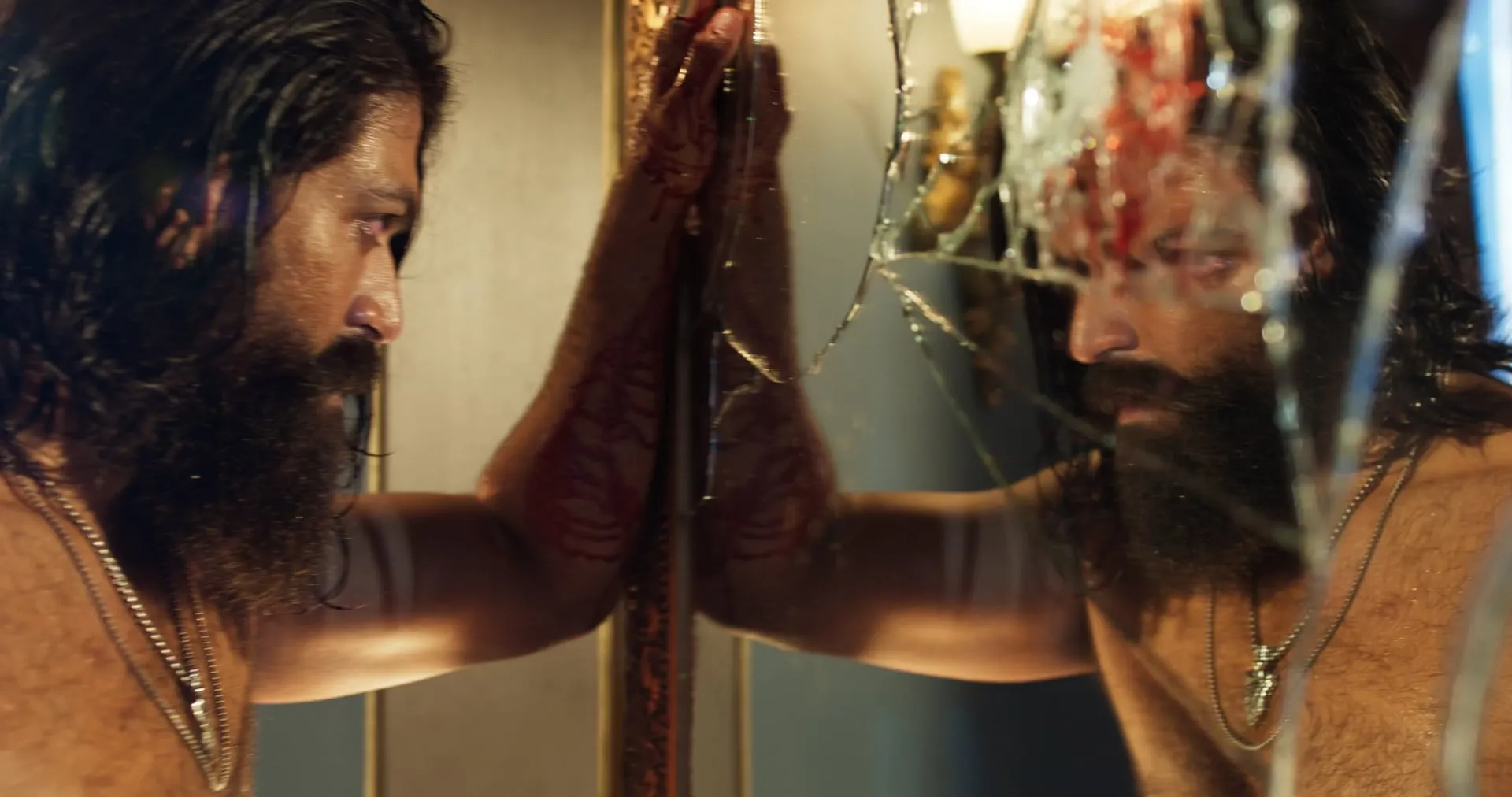 A bloodied Raya presses against a shattered mirror, staring at his own fractured reflection
