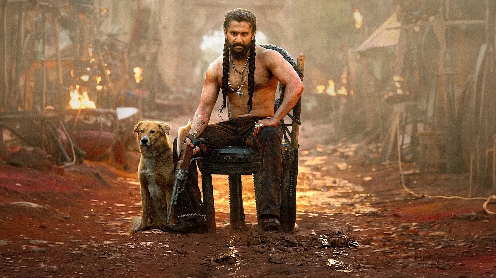 Jadal (Nani) holds court in the settlement with his dog at his feet, in a world built down to the dirt