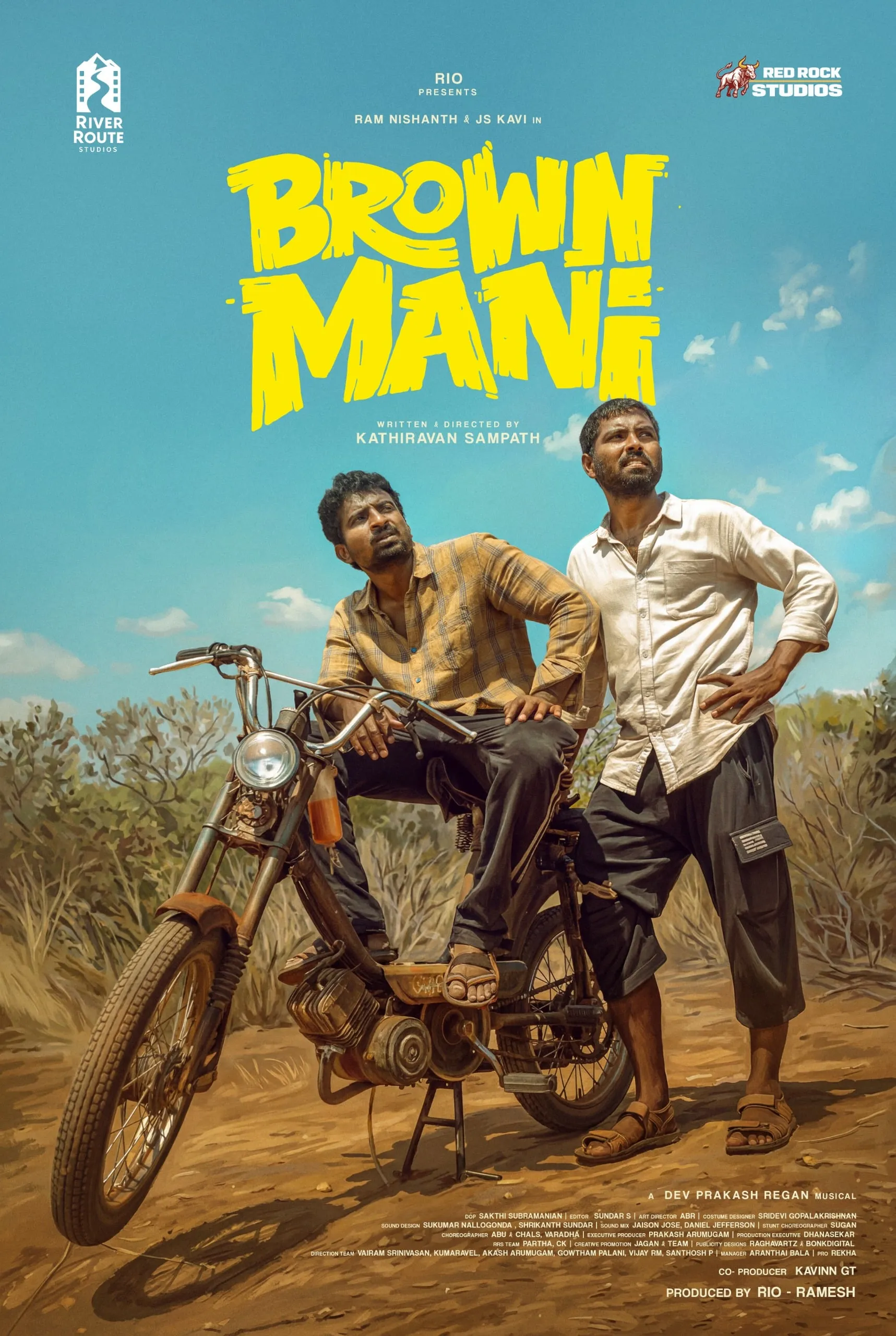 Brown Mani vertical poster with Ram Nishanth and JS Kavi posed near a motorbike under a clear sky