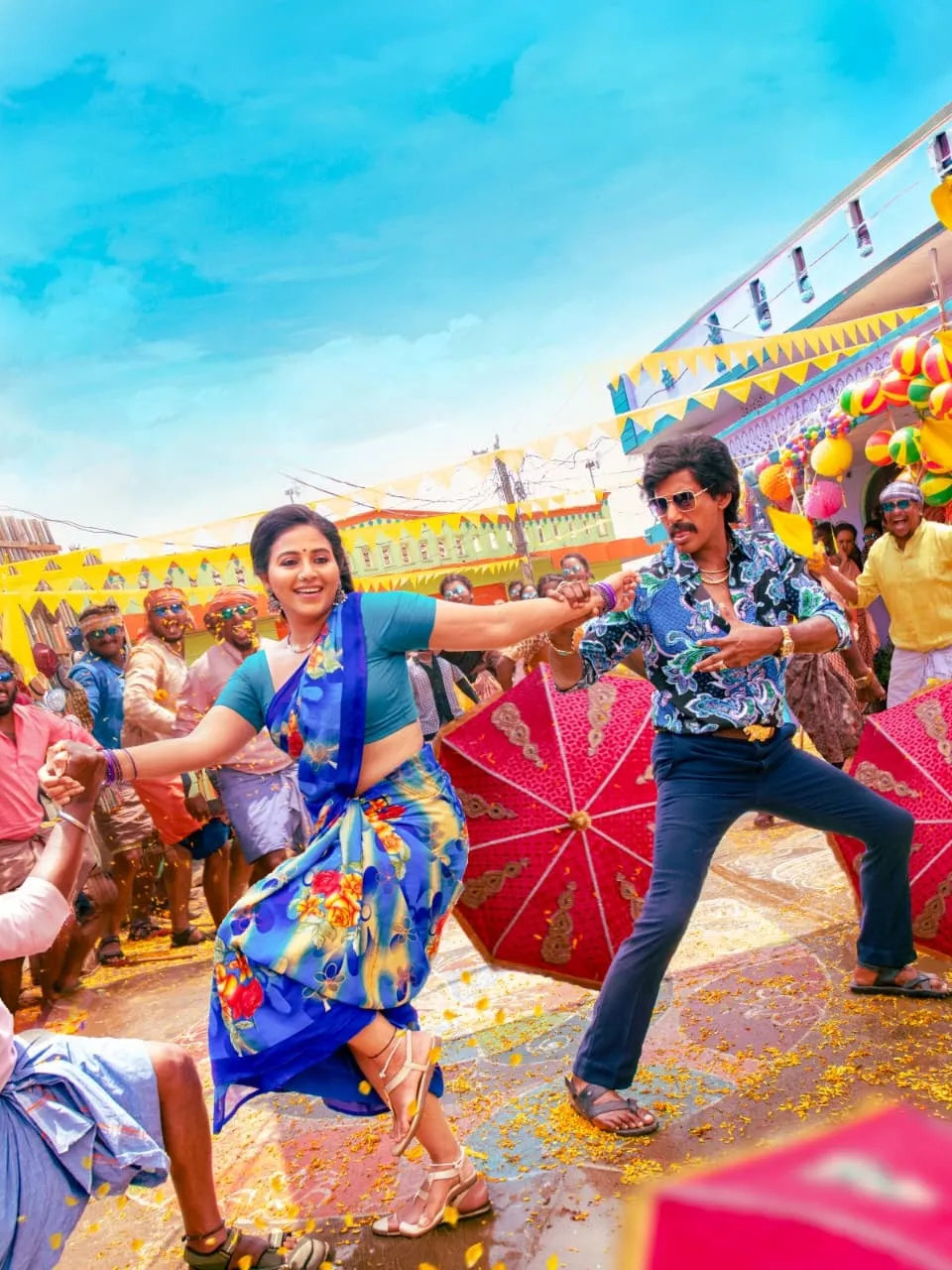 Anjali in a blue saree dances with Vishal as young Linga amid red umbrellas in a colourful village song sequence