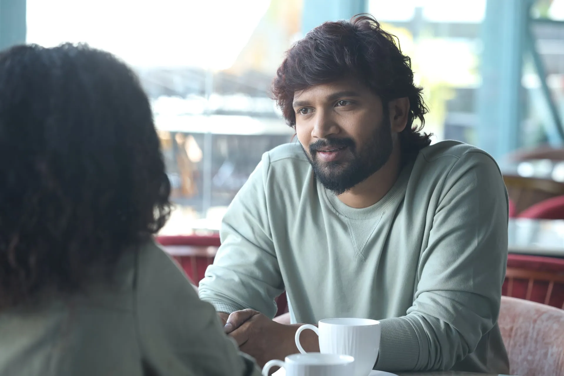 Vijay Vishwa in conversation over coffee at a cafe table