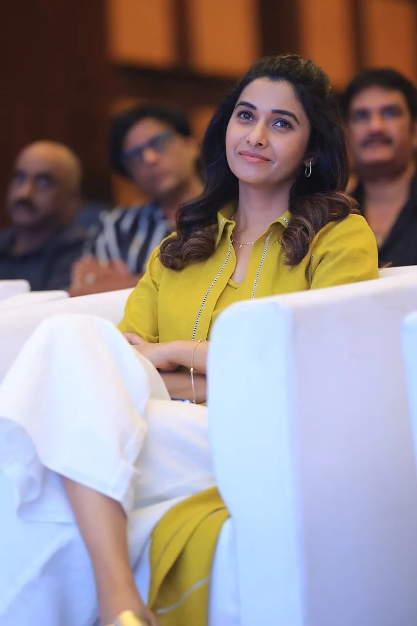 Priya Bhavani Shankar seated in the audience in a mustard kurta, smiling