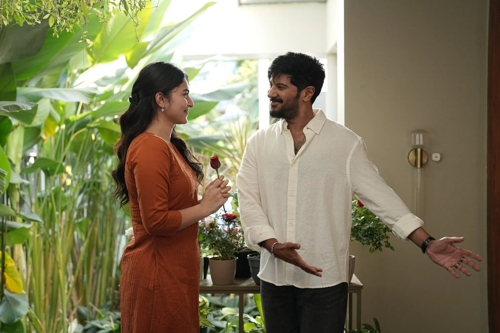 Dulquer Salmaan hands Kayadu Lohar a rose in a garden scene from I'm Game