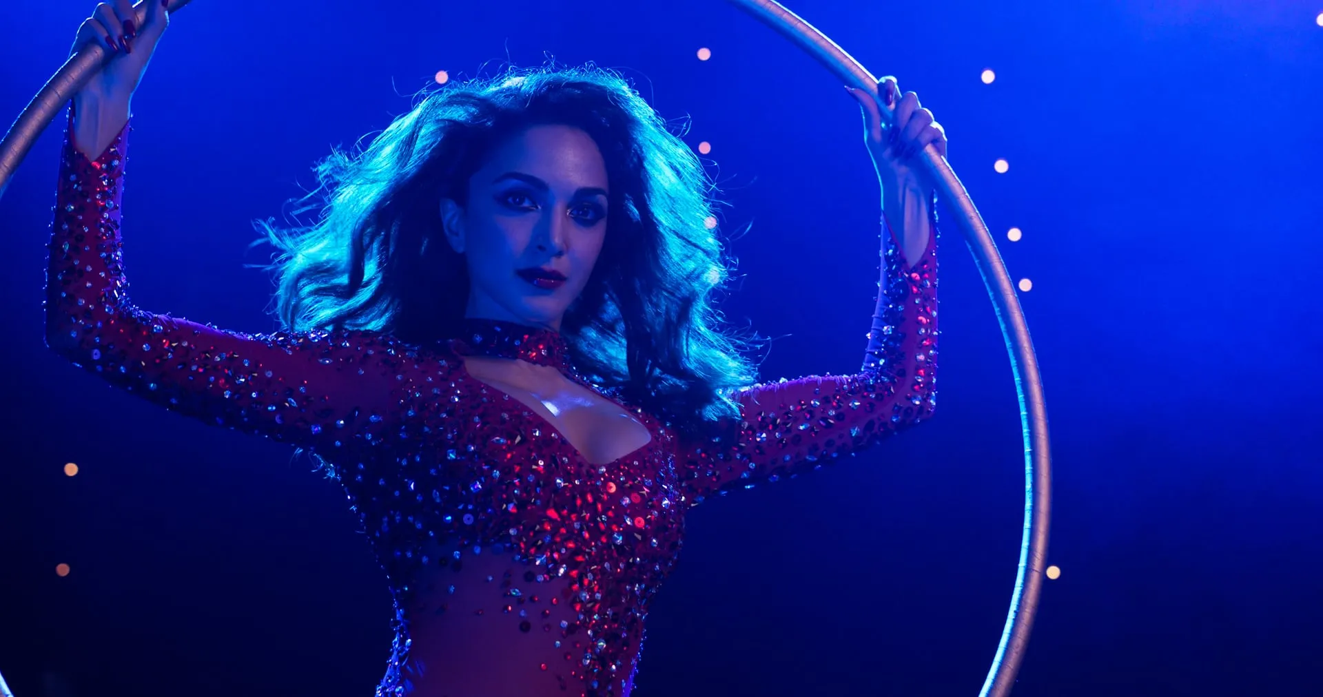 Kiara Advani as Nadia holding a hoop mid-performance under blue circus lights