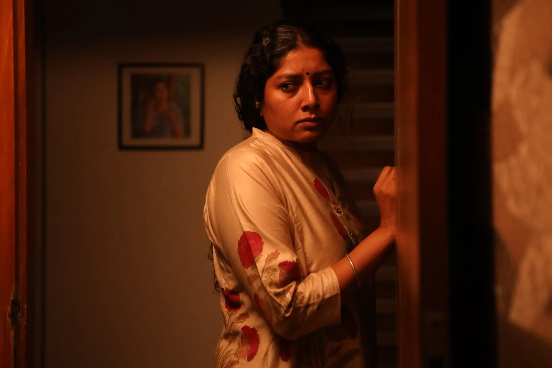 A wary glance at the doorway: once the old secret surfaces, home stops feeling safe
