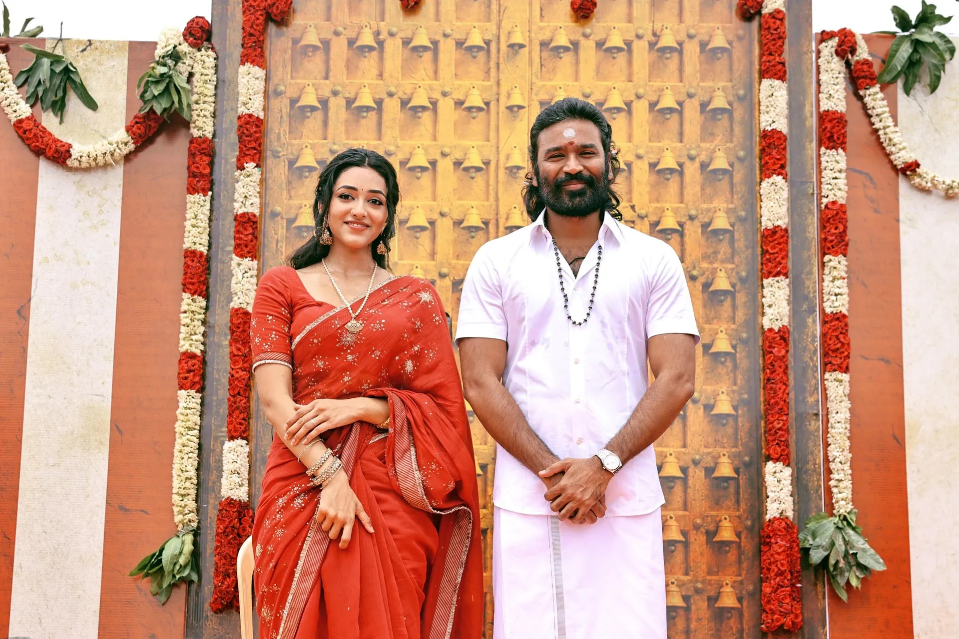 Dhanush with a D56 cast member in front of the temple door