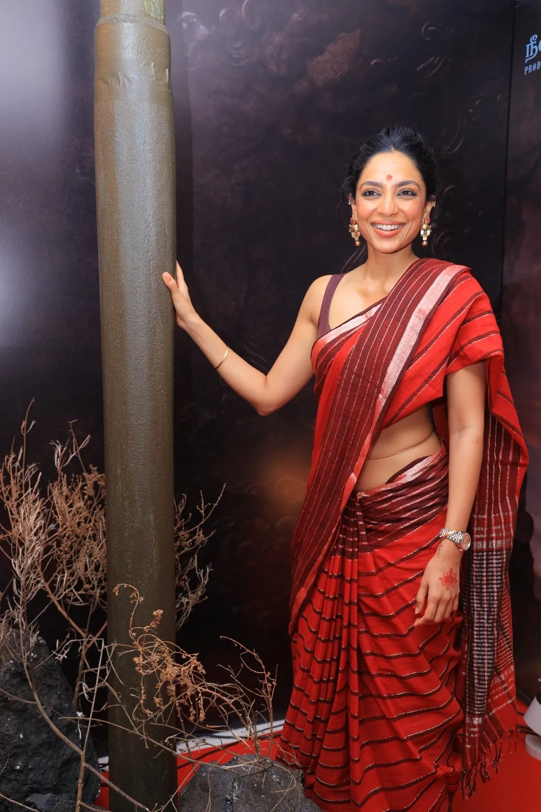 A guest in a red sari poses at the Vettuvam presentation