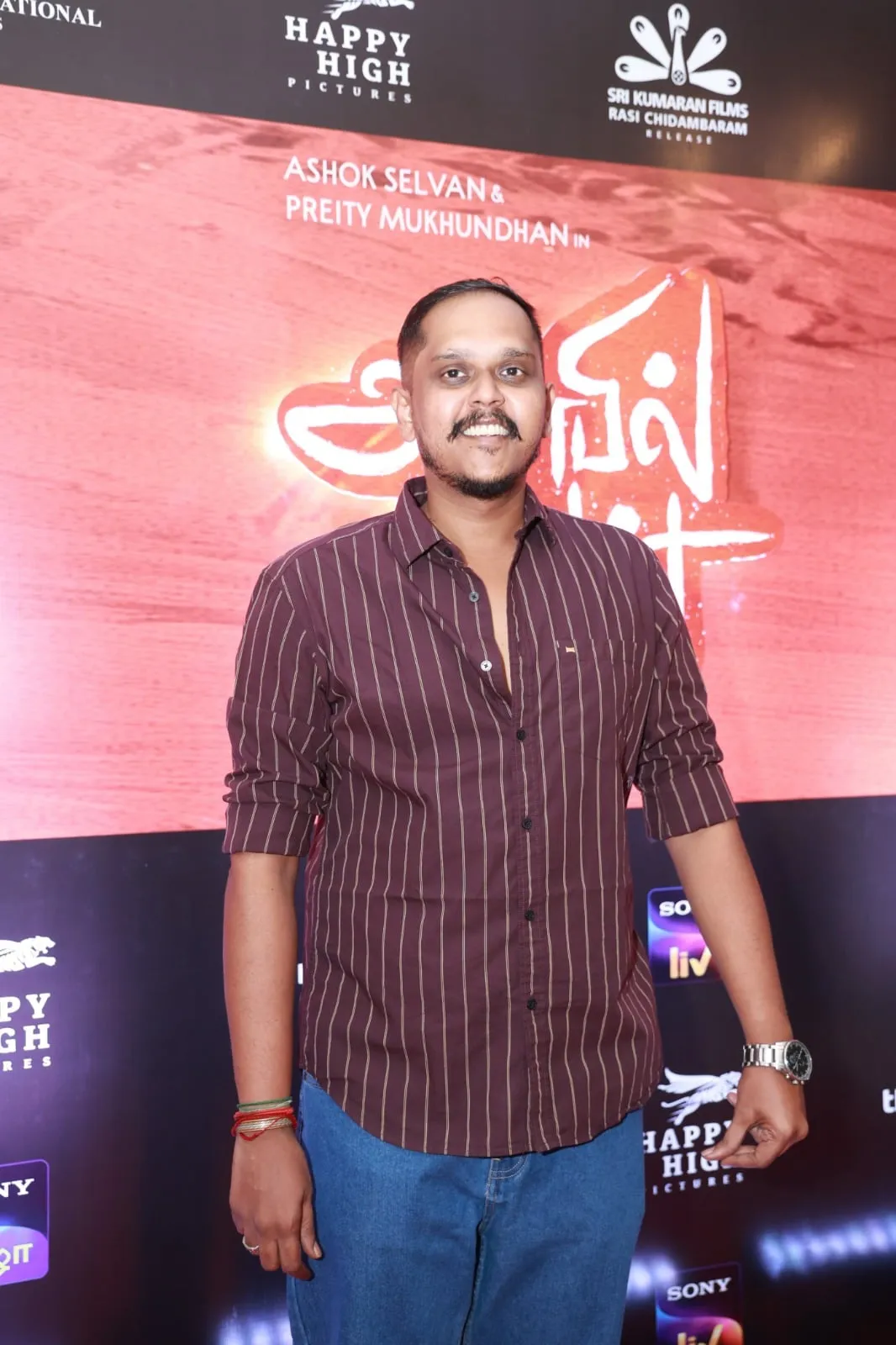 Portrait in a striped shirt at the Anbil Avan pre-release gathering
