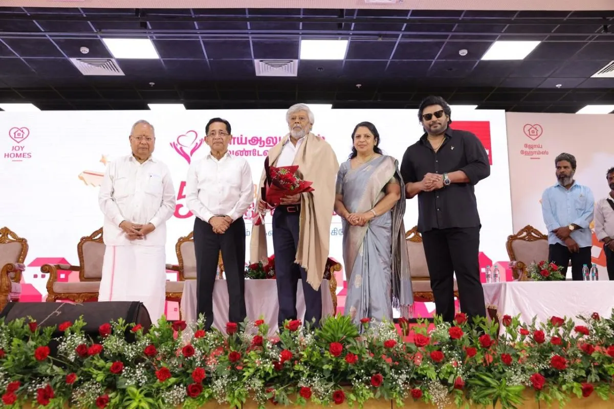 Dignitaries including Prashanth, Joy Alukkas, and Thyagarajan on stage at Joy Homes event