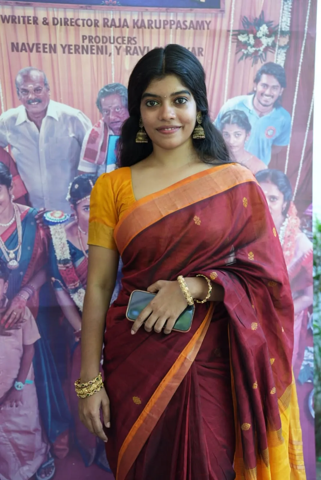 An attendee in a maroon sari and mustard blouse poses at the Modha Rathri celebration
