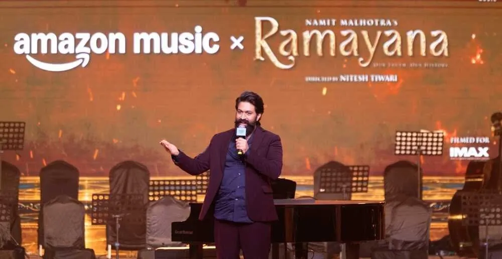 Yash gestures as he speaks on stage under the Amazon Music x Ramayana banner