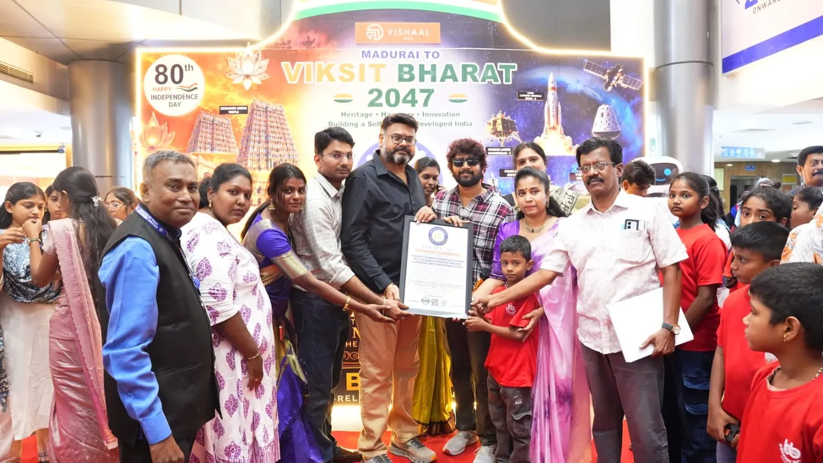 Vijay Vishwa and guests holding a record certificate at an Independence Day event at a Madurai mall