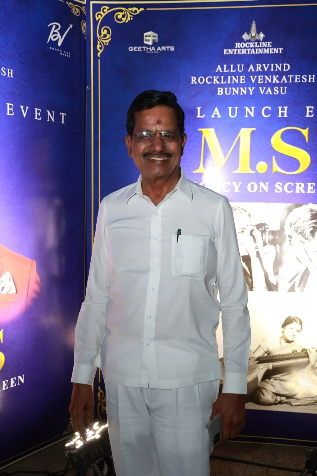 A guest poses before the M.S. film launch backdrop