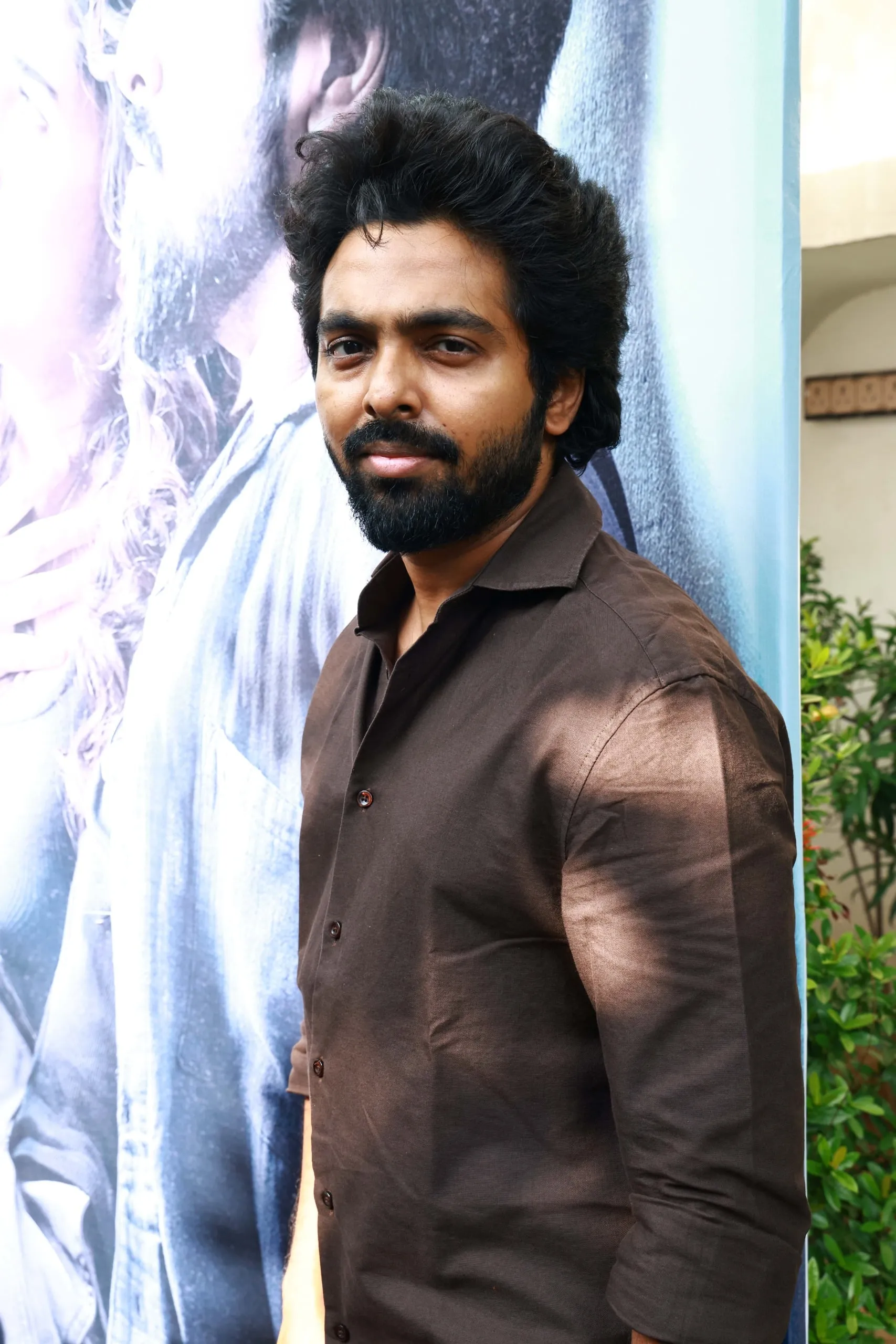 Portrait in a brown shirt against the Immortal backdrop at the success celebration