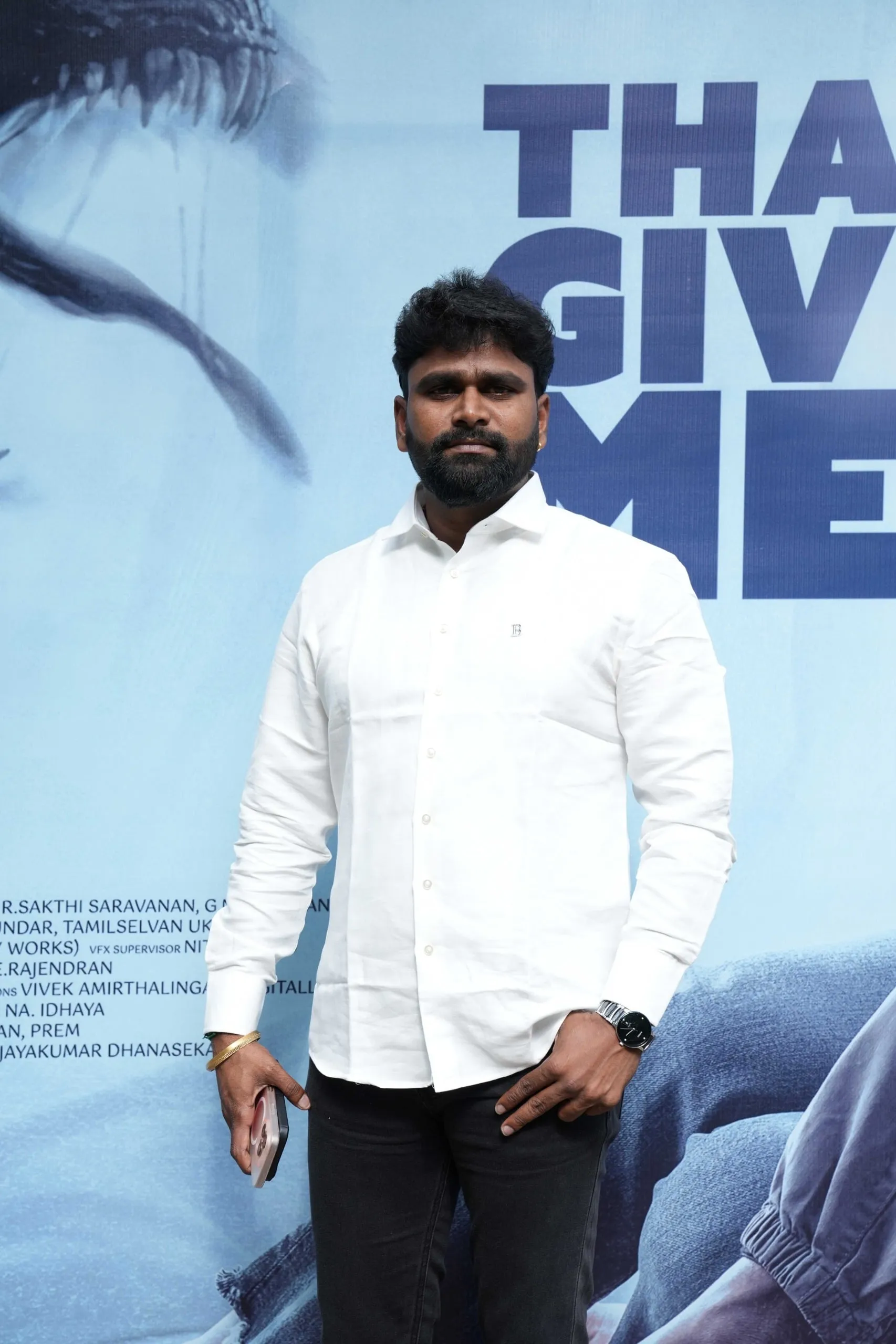 Portrait in a white shirt beside the Immortal celebration backdrop