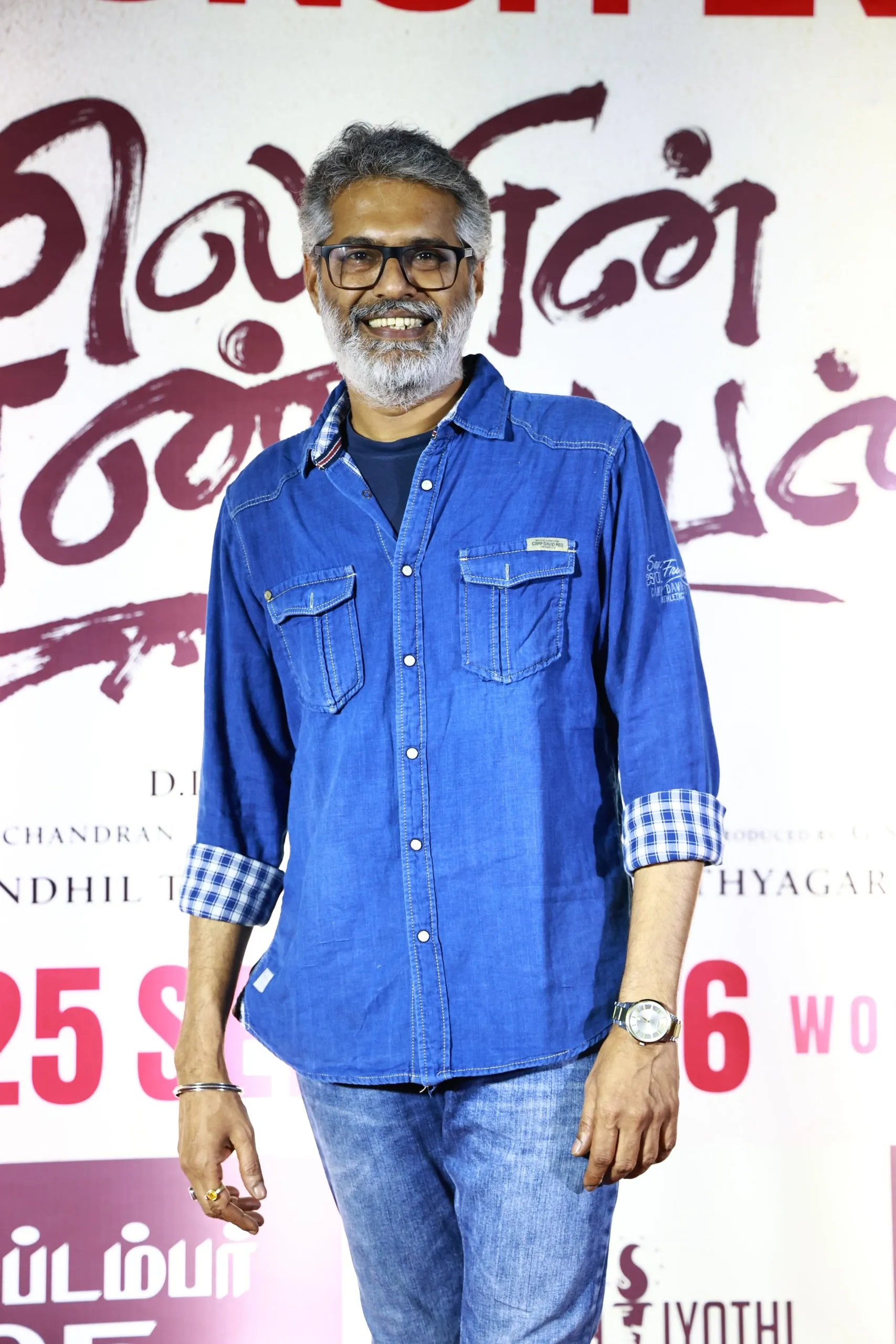 Portrait in a blue denim shirt against the film's event backdrop