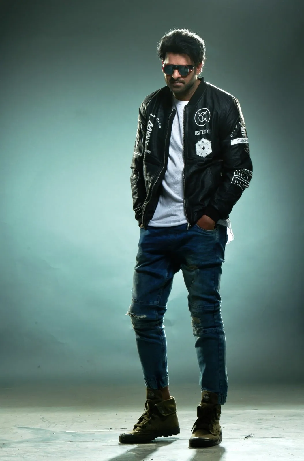 Prabhas in a full-length promotional portrait wearing a black jacket