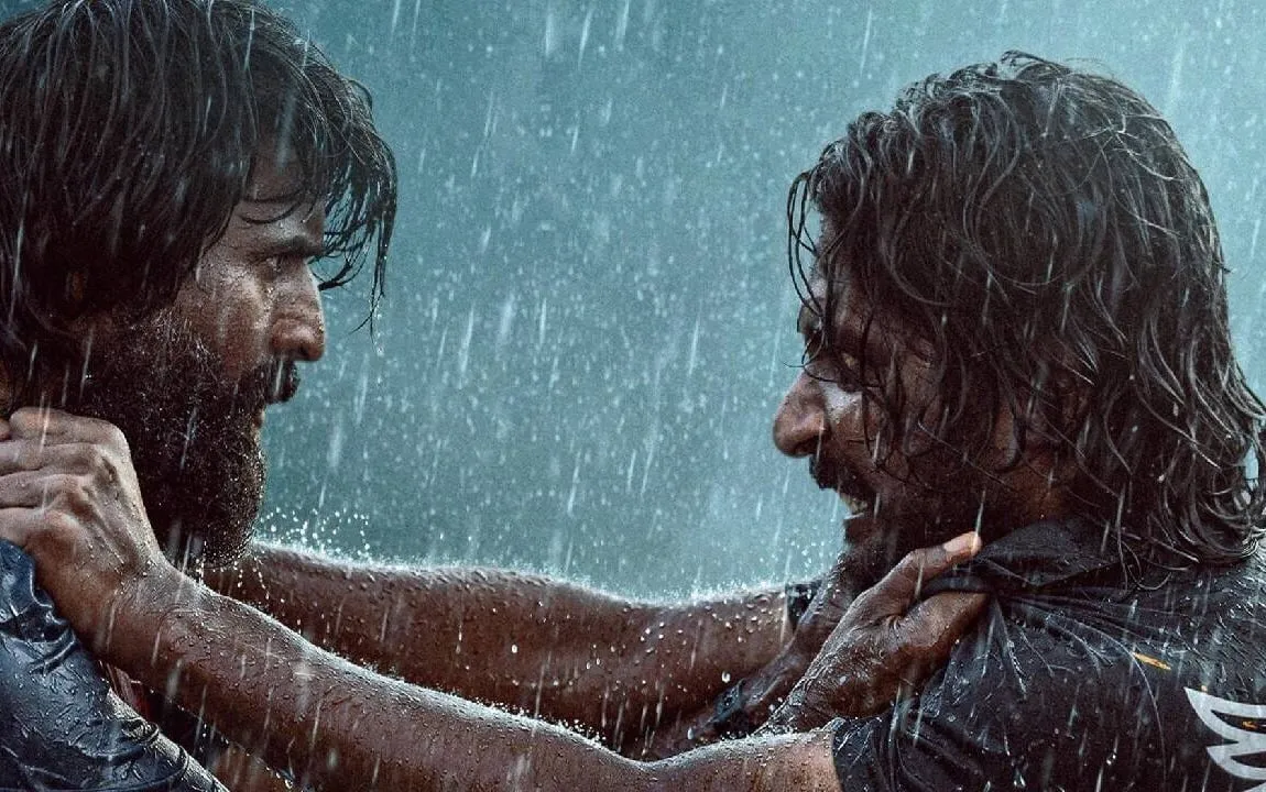 Soori and Suhas grab each other by the collar in driving rain, boats behind them, in a still from the Mandaadi trailer